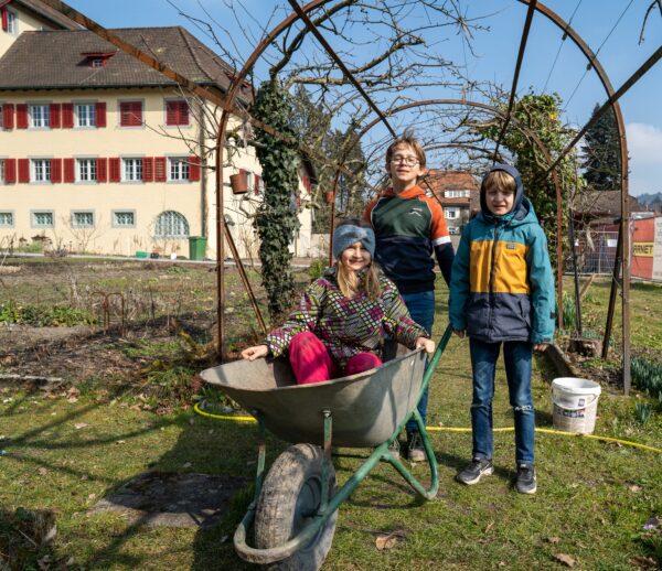 Foto: Alex Frey; Leni, Lukas und Ueli packen auf ihre Art beim Gartentag zu und haben ihren Spass daran.